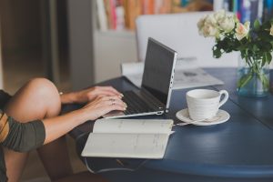 Eine Person sitzt an einem Laptop und arbeitet