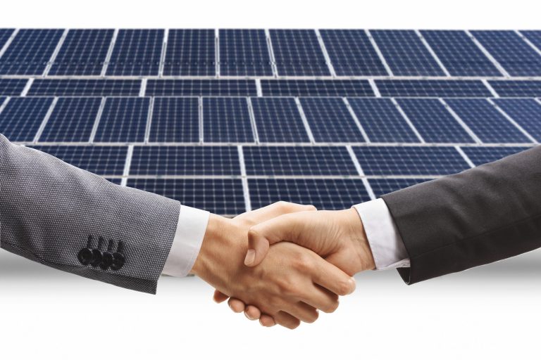 Männer schütteln sich die Hände vor einer Photovoltaikanlage, isoliert auf weißem Hintergrund